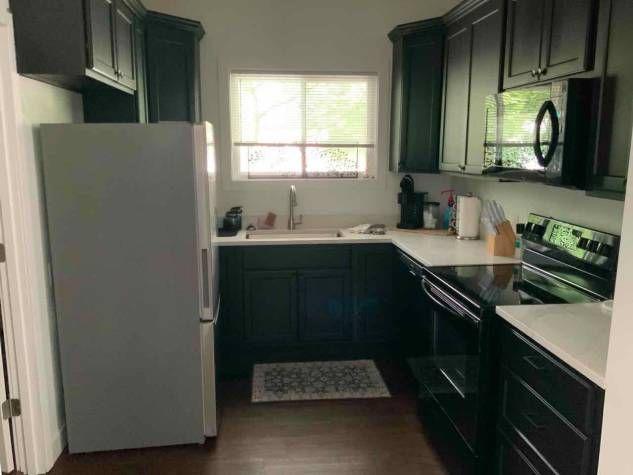 Kitchen of the short-term stay at 157 N Douglas, Springfield, IL, with dark cabinets, full-size refrigerator, and range